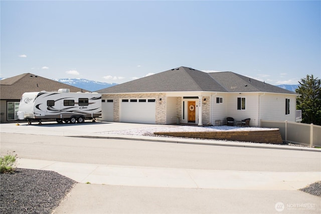 ranch-style home with a garage, fence, and driveway