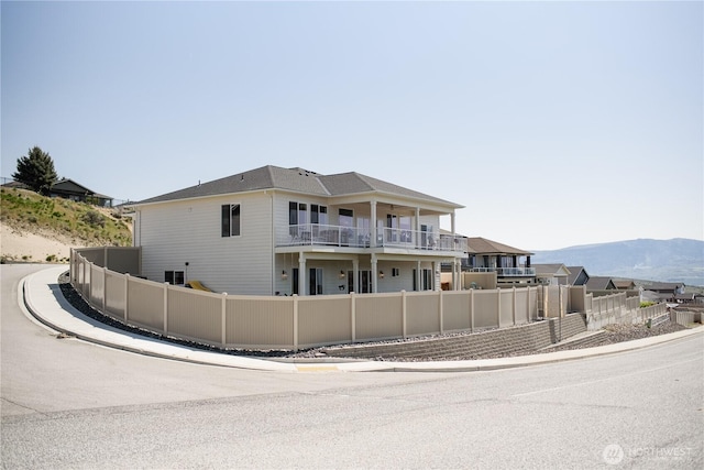 exterior space with a mountain view, fence private yard, and a balcony