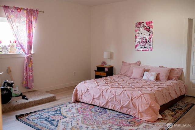 bedroom with baseboards and wood finished floors