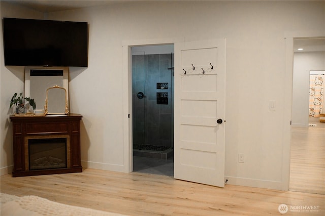 interior space with baseboards, wood finished floors, and connected bathroom
