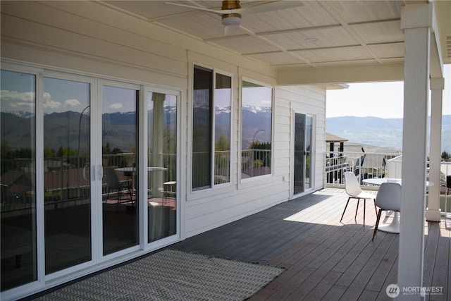 wooden terrace with a ceiling fan and a mountain view