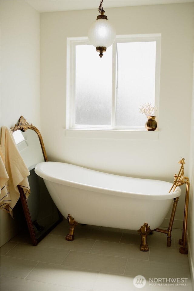 full bathroom featuring tile patterned floors and a freestanding bath