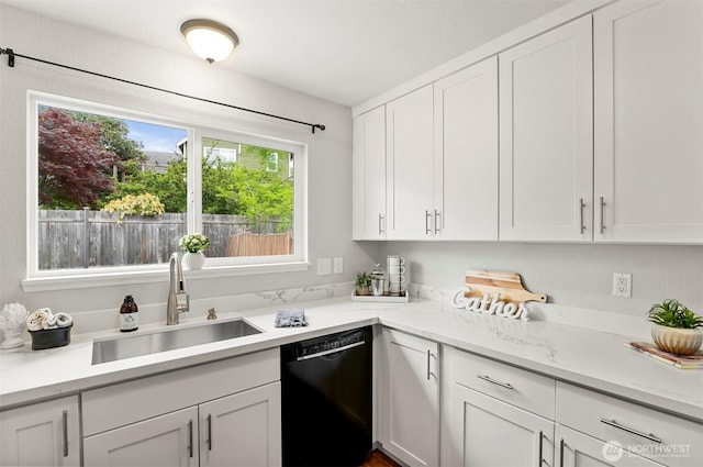 kitchen featuring white cabinets, light stone counters, a sink, and dishwasher