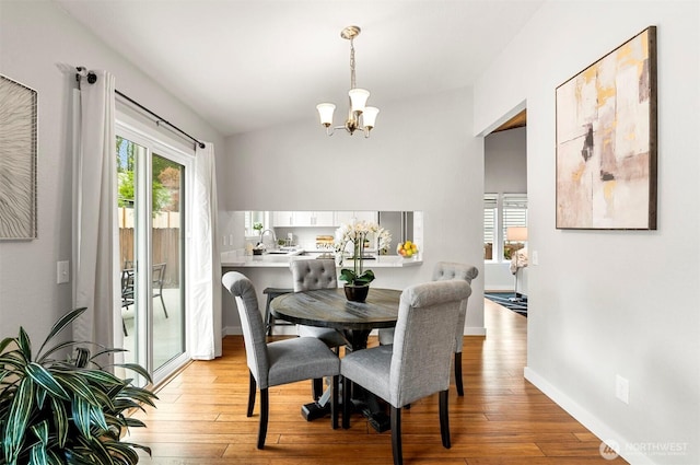 dining room with baseboards, light wood-style flooring, and a chandelier