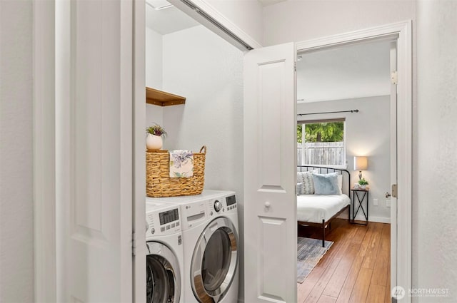 laundry room featuring washing machine and clothes dryer, laundry area, and light wood-type flooring