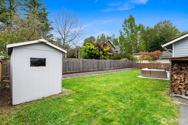 view of yard with an outdoor living space, a fenced backyard, and a storage shed