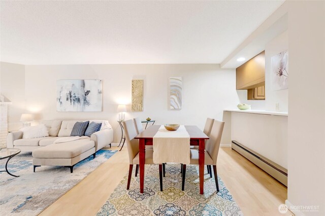 dining room with recessed lighting, baseboards, a baseboard heating unit, and light wood finished floors