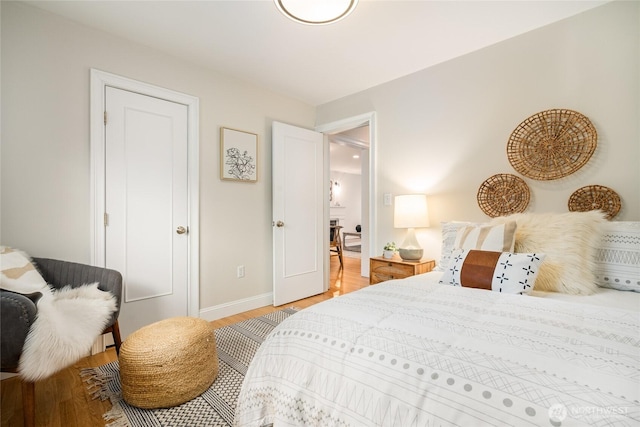 bedroom with baseboards and light wood finished floors