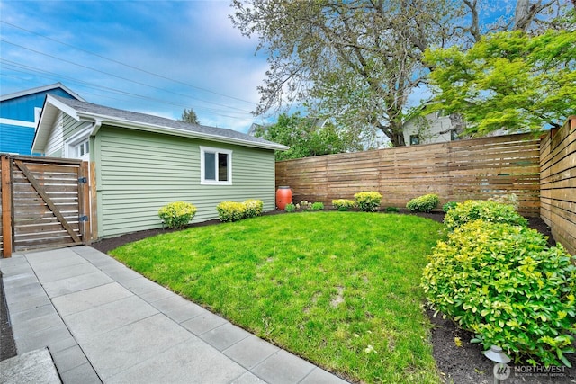 view of yard with a fenced backyard and a gate