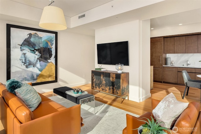 living room featuring visible vents and light wood-style flooring