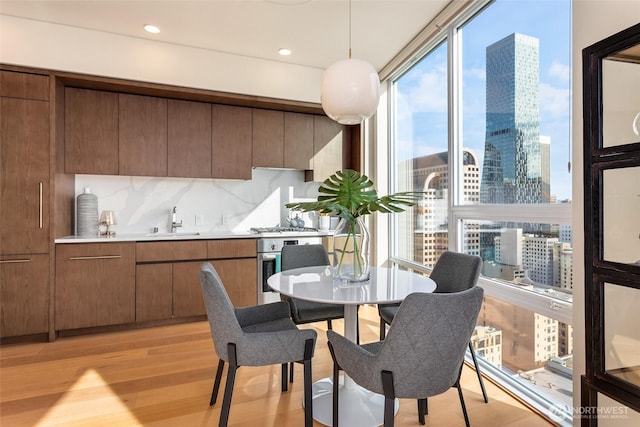dining area with light wood-style floors and a city view