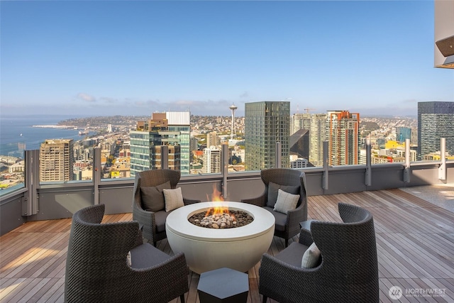 wooden terrace with a view of city and an outdoor fire pit