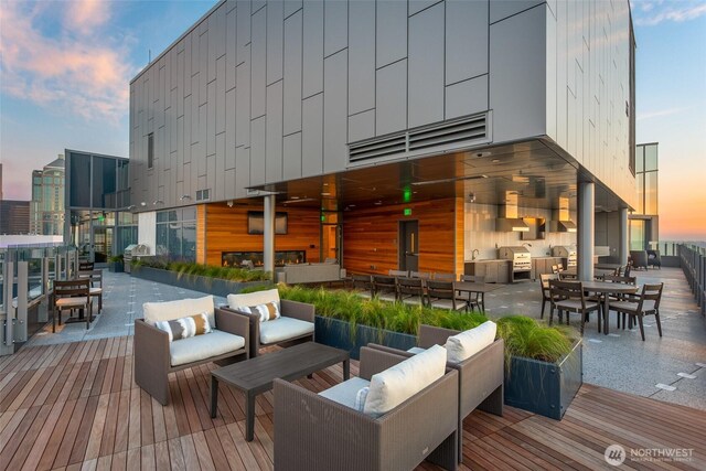 deck at dusk with area for grilling, an outdoor hangout area, and outdoor dining space