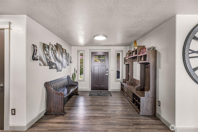 foyer featuring baseboards, a textured ceiling, and dark wood finished floors
