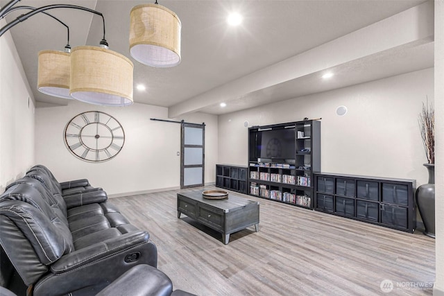 living area with recessed lighting, baseboards, a barn door, and wood finished floors