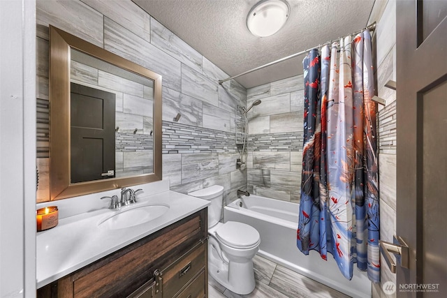 bathroom with vanity, shower / tub combo with curtain, a textured ceiling, and toilet