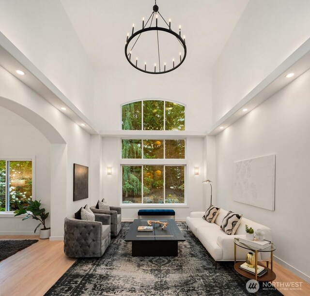 9732 Slater Ave NE, Kirkland, WA 98033 - living room with a high ceiling, arched walkways, a chandelier, recessed lighting, and wood finished floors