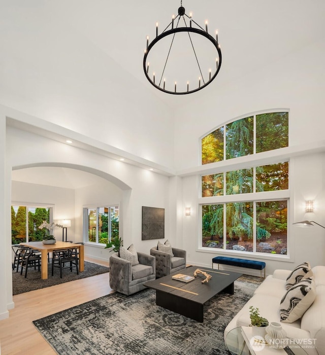 9732 Slater Ave NE, Kirkland, WA 98033 - living area featuring arched walkways, a towering ceiling, wood finished floors, and a chandelier