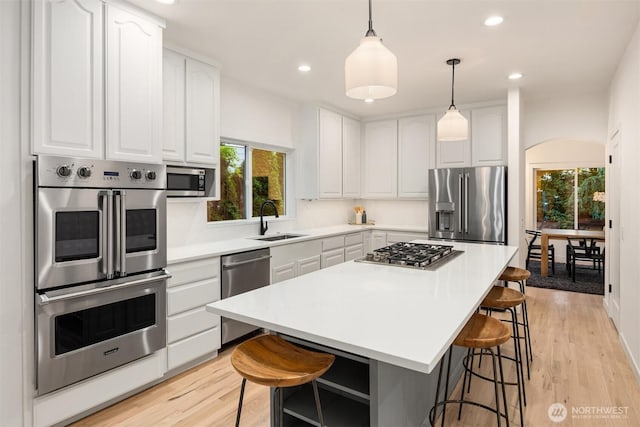 9732 Slater Ave NE, Kirkland, WA 98033 - kitchen featuring white cabinets, open shelves, appliances with stainless steel finishes, a sink, and a kitchen bar