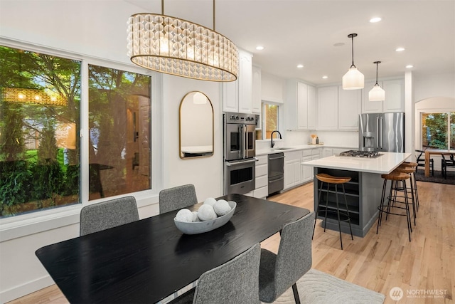9732 Slater Ave NE, Kirkland, WA 98033 - dining room featuring recessed lighting, arched walkways, and light wood-style flooring