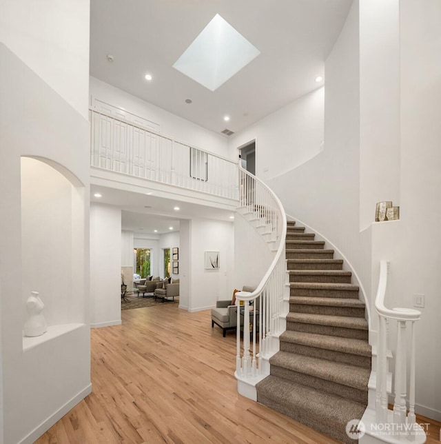 9732 Slater Ave NE, Kirkland, WA 98033 - stairway featuring recessed lighting, baseboards, a towering ceiling, and wood finished floors