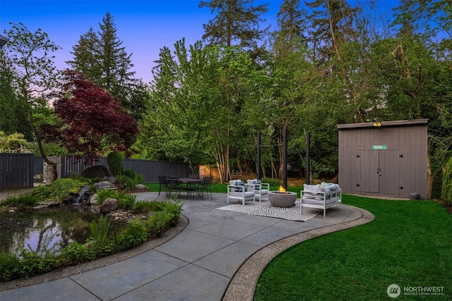 9732 Slater Ave NE, Kirkland, WA 98033 - patio terrace at dusk with an outdoor structure, fence, an outdoor hangout area, a storage shed, and a yard