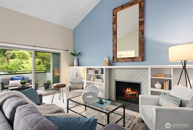 living area with a tiled fireplace and high vaulted ceiling