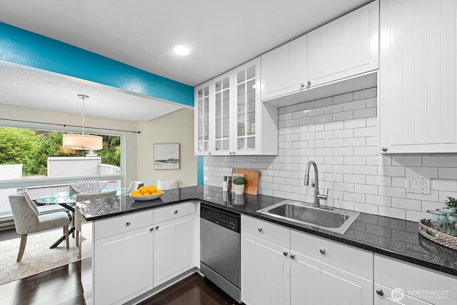 kitchen with white cabinets, dark wood-style flooring, a sink, dishwasher, and a peninsula