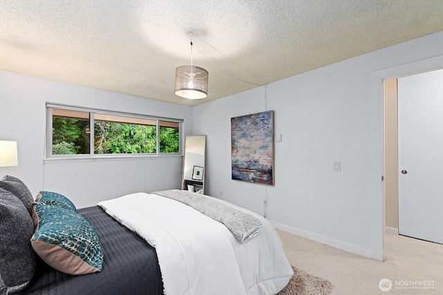 bedroom featuring baseboards, a textured ceiling, and light carpet