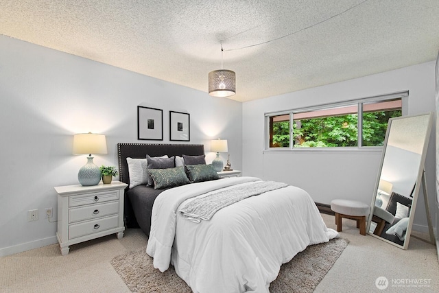 bedroom with a textured ceiling, light colored carpet, and baseboards