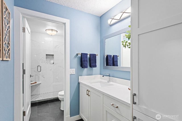 bathroom featuring a textured ceiling, baseboards, vanity, toilet, and a marble finish shower