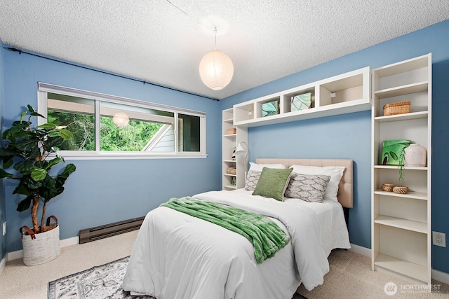carpeted bedroom featuring baseboards, a baseboard heating unit, and a textured ceiling