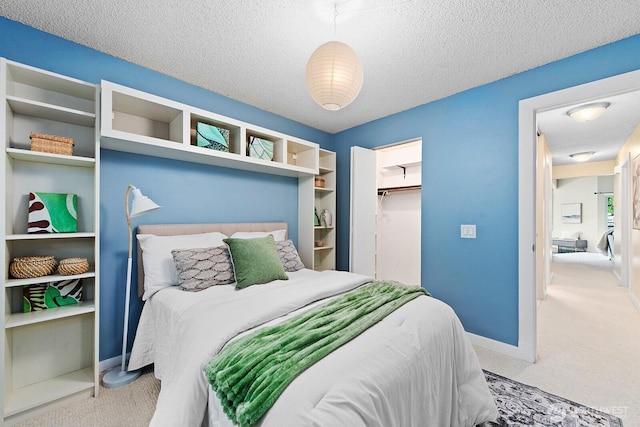 bedroom featuring baseboards, a textured ceiling, carpet, and a closet