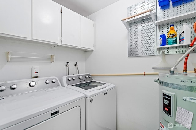 washroom with cabinet space, washer and clothes dryer, and electric water heater