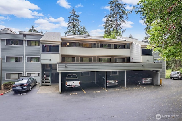 rear view of house featuring covered parking and stairs