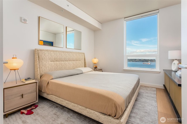 bedroom featuring light wood-style floors and baseboards
