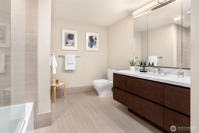 full bathroom featuring vanity, toilet, a tub, baseboards, and a shower