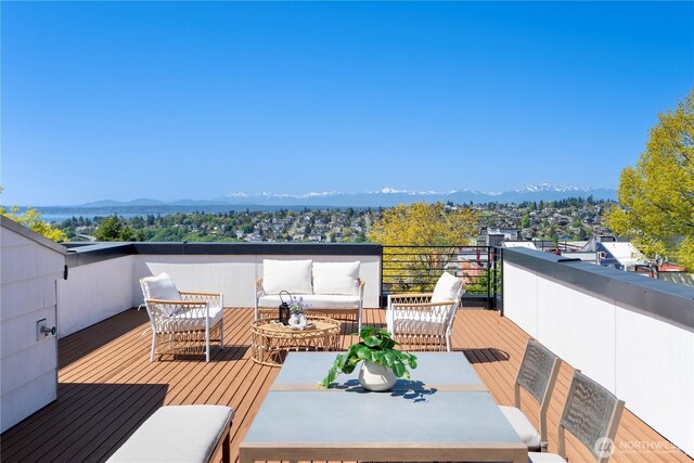 wooden terrace with outdoor lounge area and a mountain view
