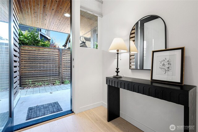 doorway to outside with baseboards and wood finished floors
