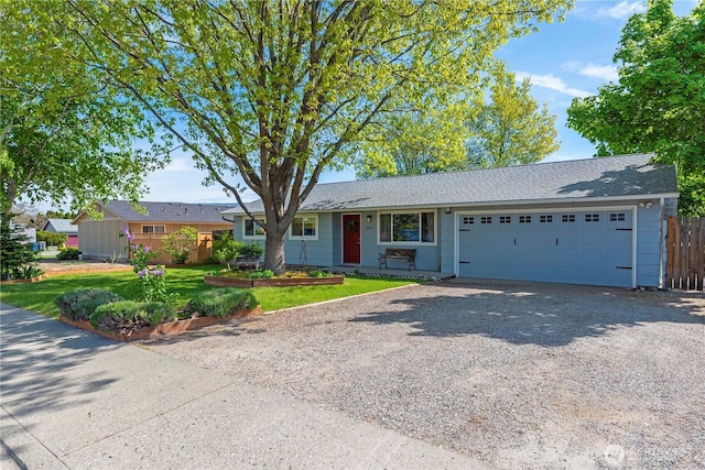 single story home featuring fence, roof with shingles, an attached garage, a front yard, and driveway