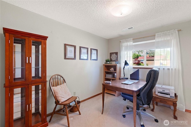 home office with a textured ceiling, visible vents, light carpet, and baseboards