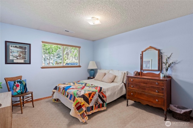 carpeted bedroom featuring a textured ceiling and visible vents