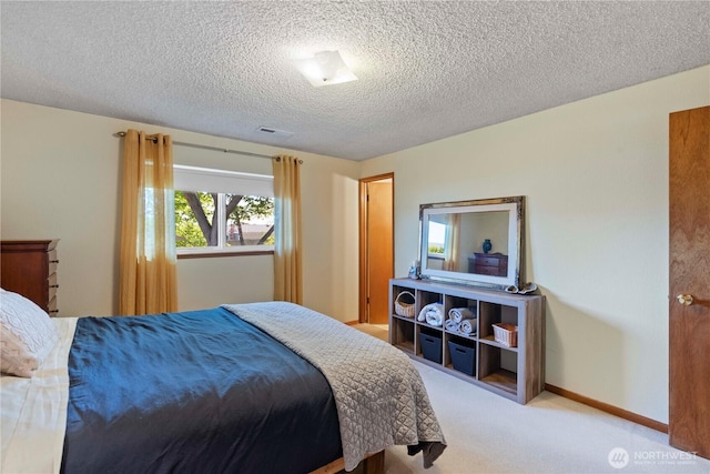 carpeted bedroom with visible vents, a textured ceiling, and baseboards