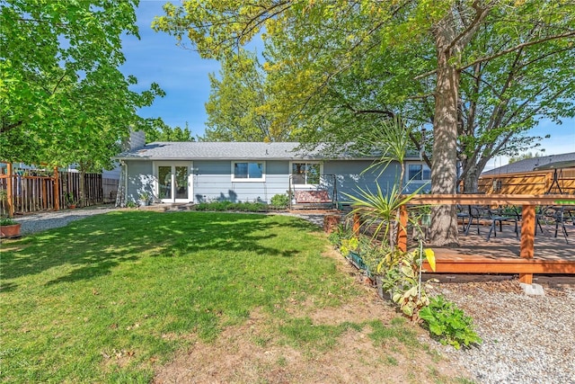 back of house with french doors, a chimney, a lawn, a wooden deck, and fence
