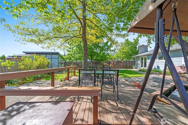 wooden terrace featuring outdoor dining area and a fenced backyard