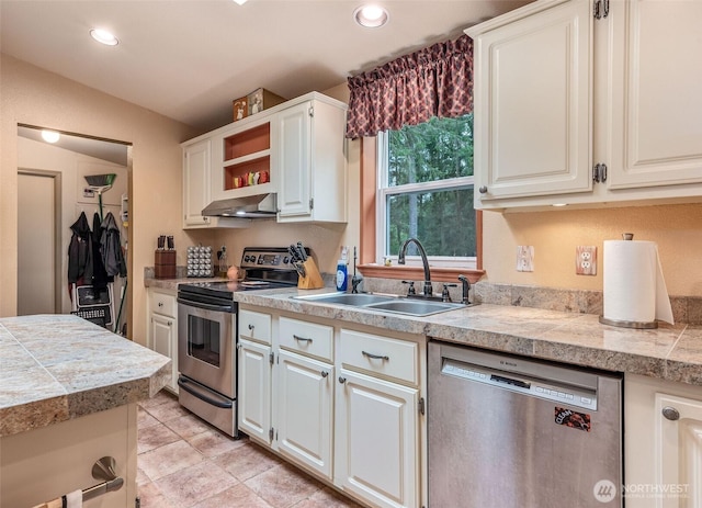 kitchen with tile counters, recessed lighting, a sink, exhaust hood, and stainless steel appliances