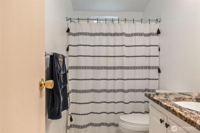 bathroom featuring toilet, curtained shower, and vanity