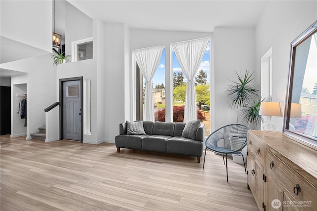 6411 86th Street Ct E, Puyallup, WA 98371 - sitting room with stairway, high vaulted ceiling, an inviting chandelier, and light wood finished floors