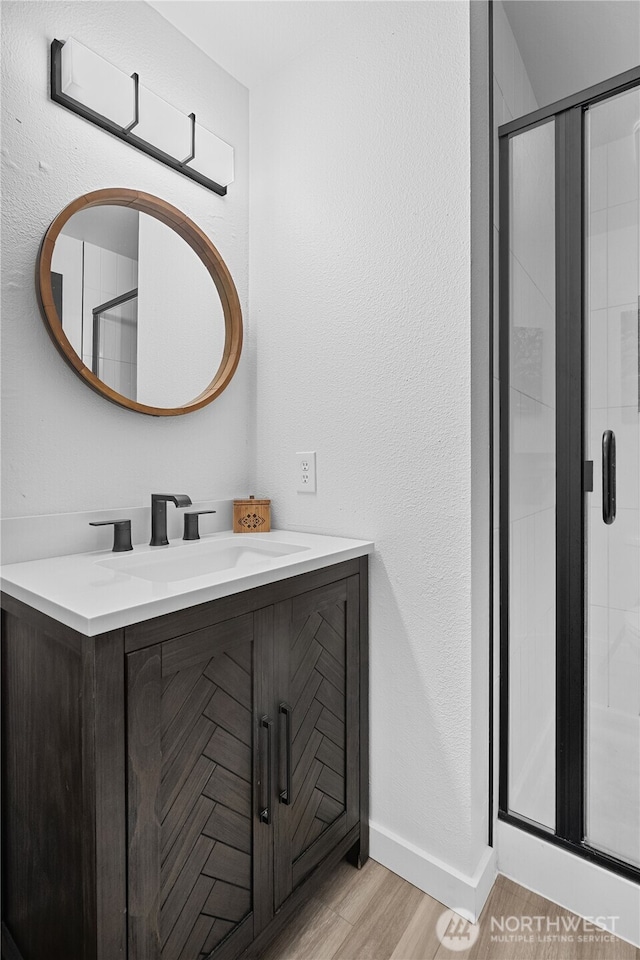 6411 86th Street Ct E, Puyallup, WA 98371 - full bathroom with vanity, baseboards, wood finished floors, and a stall shower