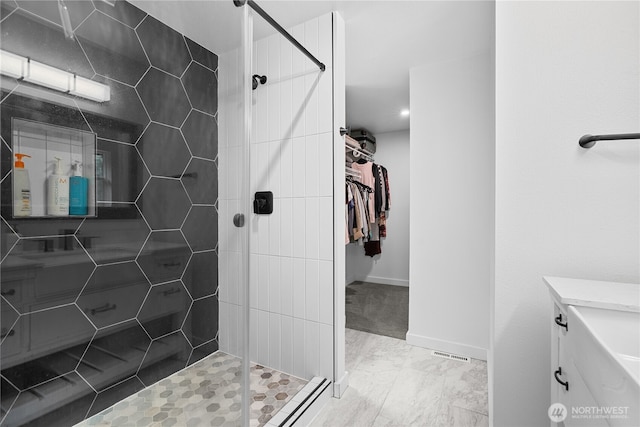 6411 86th Street Ct E, Puyallup, WA 98371 - bathroom featuring baseboards, a walk in closet, tiled shower, and vanity